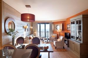 a living room with a table and chairs and a television at Résidence Pierre & Vacances Premium L'Amara in Avoriaz