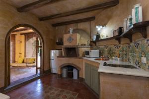 Il comprend une cuisine avec un évier et une cheminée. dans l'établissement Dimora Migliori, à Viagrande