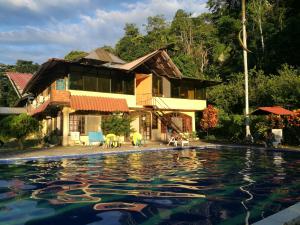 a house with a swimming pool in front of it at Grand Selva Lodge & Tours in Tena