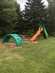 zwei Kinderspielplätze in einem Park in der Unterkunft Ermitage Saint-Antoine in Lac-Bouchette