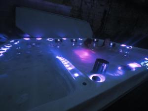 a bathtub with lights in a dark room at Spa de campagne Ressource gite THALASSO privatisée INCLUS in Dormelles