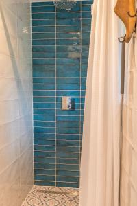 een douche met een douchegordijn in de badkamer bij B&B De Oude Skuur Ooi in Oosterend