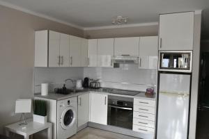 a kitchen with white cabinets and a washing machine at Departamento Ingrid in Puerto del Carmen
