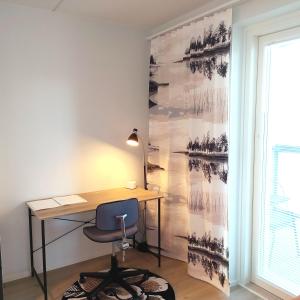 a desk and a chair in a room with a wall at Ihana uusi huoneisto, hyvällä sijainnilla in Seinäjoki