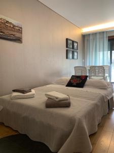 - une chambre avec un lit et des serviettes dans l'établissement I love alegria, à Porto