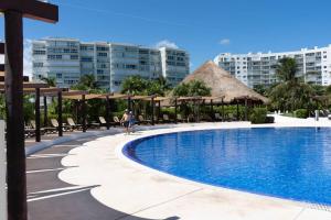 a woman standing next to a swimming pool at a resort at Amara By Andiani in Cancún