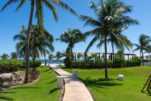 einen Weg durch einen Park mit Palmen in der Unterkunft Amara By Andiani in Cancún