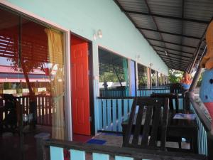 a building with a red door and a table and chairs at Nam Pueng Place 2 in Chiang Saen