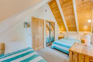 1 Schlafzimmer mit 2 Betten und Holzdecke in der Unterkunft Cabin in the Woods in Tahoma