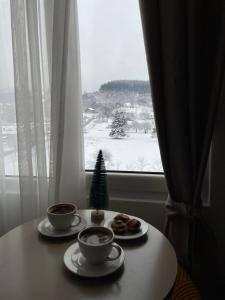 una mesa con dos tazas de café y un árbol de Navidad en Modern Mountain EXCLUSIVE en Kolašin