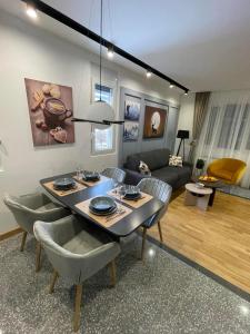 sala de estar con mesa, sillas y sofá en Modern Mountain EXCLUSIVE en Kolašin