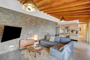 a living room with a blue couch and a brick wall at Linaje del Pago Malvasia in Sauzal
