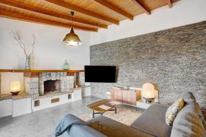 a living room with a stone wall and a couch at Linaje del Pago Malvasia in Sauzal