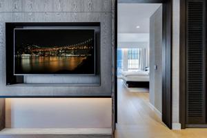 sala de estar con TV en la pared en Equinox Hotel Hudson Yards New York City, en Nueva York