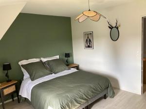 a bedroom with a bed and two tables with lamps at LE GÎTE DES BLEUETS in Cany-Barville