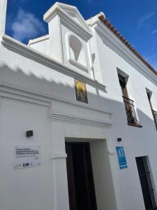 eine weiße Kirche mit einem Kreuz auf der Seite in der Unterkunft Apartamentos Molinos in Constantina