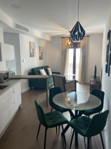 a living room with a table and green chairs at Apartamentos Molinos in Constantina