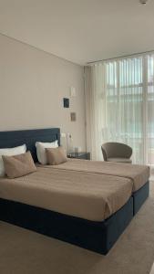 um quarto com uma cama grande e uma janela grande em FH Hotel Rural em Felgueiras
