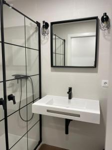 a bathroom with a white sink and a mirror at Apartamentos Molinos in Constantina