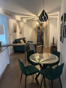 a living room with a table and green chairs at Apartamentos Molinos in Constantina