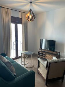 sala de estar con sofá y TV en Apartamentos Molinos en Constantina
