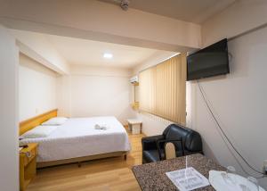 a hotel room with a bed and a television at Condall Palace Hotel in Nova Prata