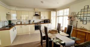 a kitchen with a table and a dining room at Shore Thing Beachfront Apartment Ramsgate - Sleeps 4 in Ramsgate