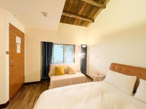 a bedroom with two beds and a window at Jiufen Breeze 九份惠風民宿ｌ6人包棟小屋 in Jiufen