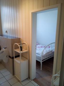 ein Badezimmer mit einem Schlafzimmer, das mit einem Bett und einem Spiegel ausgestattet ist. in der Unterkunft Zum Bothmerschen Krug in Schwarmstedt + 68 Fotos