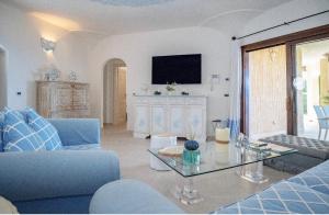 a living room with a blue couch and a glass table at Residenza Grazia sul mare in Abbiadori