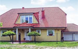 ein Haus mit rotem Dach und zwei Bäumen davor in der Unterkunft Cozy Home In Kamien With Kitchen in Kamień