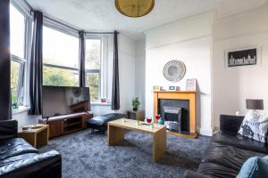a living room with a couch and a tv and a table at Merseybeat Short stays in Birkenhead