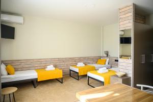 uma sala de estar com duas camas e almofadas amarelas em Space Apart Hotel em Lutsk