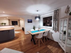 a kitchen and living room with a table and chairs at Ferienwohnung Chiemseeliebe in Chieming