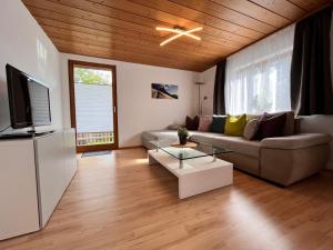 ein Wohnzimmer mit einem Sofa und einem TV in der Unterkunft Ferienhaus Schwangau in Schwangau