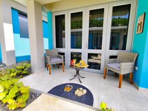 a patio with two chairs and a table on a porch at Villas at Chalet De Buye in Cabo Rojo