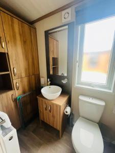 a bathroom with a white toilet and a sink at Coopers Corner, Lodge with Hot Tub in York