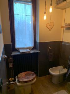 a bathroom with a toilet and a window at Pirola Music Ranch Guest House B&B in Romano di Lombardia