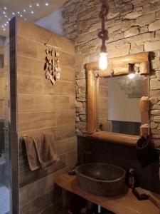 a bathroom with a sink and a stone wall at Pirola Music Ranch Guest House B&B in Romano di Lombardia