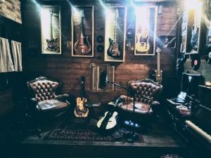 een muziekkamer met twee stoelen en een stel gitaren bij Pirola Music Ranch Guest House B&B in Romano di Lombardia