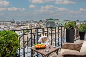巴黎的住宿－Hôtel Pont Royal Paris，阳台上的桌子上放着一碗水果