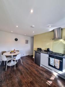 uma cozinha com uma mesa, um fogão, uma mesa e cadeiras em No.2 Bloom Apartments, Bath em Bath