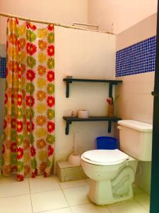a bathroom with a toilet and a shower curtain at Reserva Natural La Esperanza in Girocasaca