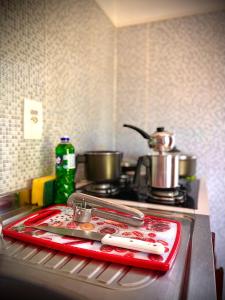 a kitchen counter with a red tray on a stove at Residencial Bem-te-vi in Jericoacoara