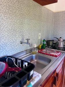 a kitchen counter with a sink and a stove at Residencial Bem-te-vi in Jericoacoara