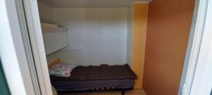 um pequeno armário com uma pequena cama em Mobil home au coeur de Brocéliande em Paimpont