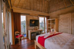 a bedroom with a bed and a television in a room at Aget Private Villas in Toyapakeh