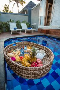 a basket of fruit sitting in a swimming pool at Aget Private Villas in Toyapakeh
