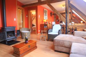 a living room with a couch and a stove at Gite ferme XVIII 4 chambres /8 personnes Chimay in Momignies