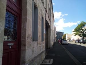 ein Gebäude mit einer roten Tür auf der Straßenseite in der Unterkunft Studio confortable in Rochefort